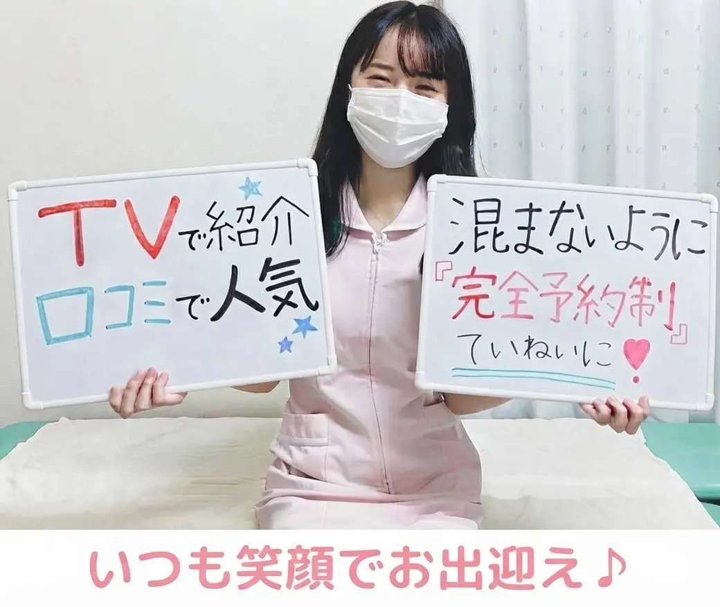 ピンクの白衣を着た受付スタッフの写真